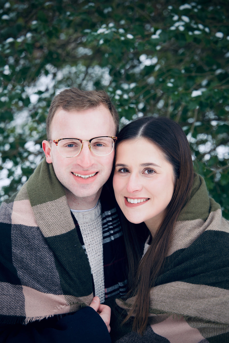 Two people hugging with a snowy tree background